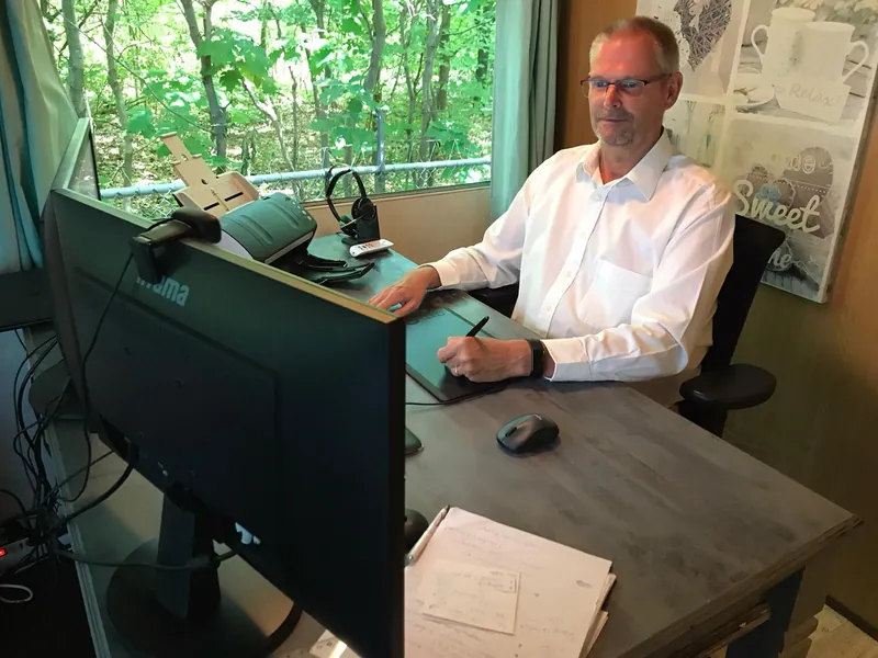 Joep van der Pol aan zijn bureau, met een tekentablet voor zich en een groot scherm